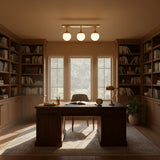 Modern brass 3-globe ceiling light with rectangular canopy, short stems, and soft ambient illumination