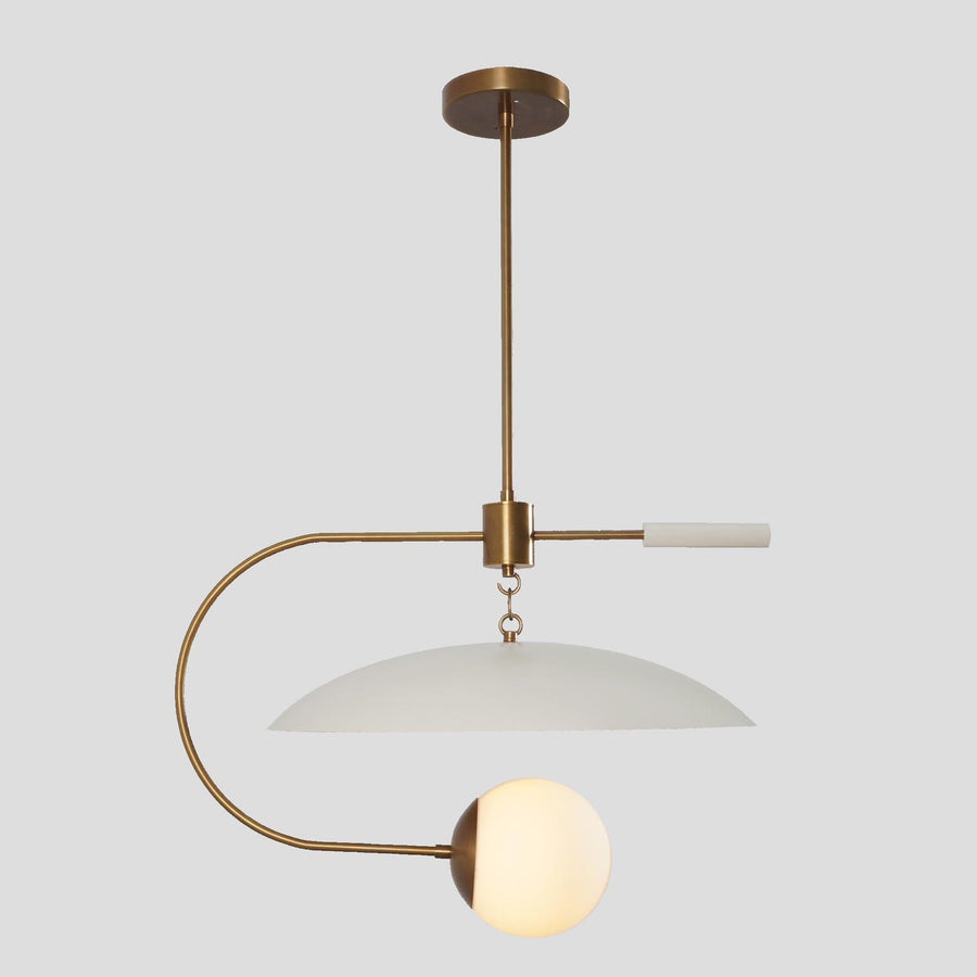 Modern brass pendant light featuring a white dome shade and frosted globe design, creating a balanced minimalist statement for contemporary interiors.