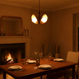 Modern brass bedroom chandelier with three opal glass globes creating a soft warm glow above a cozy bed setting