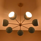 Brass chandelier with blue globe shades glowing warmly against ceiling.