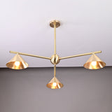 Close-up view of modern brushed brass chandelier with three cone-shaped shades, showcasing elegant handcrafted ceiling light design