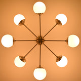 Modern brass chandelier with glowing opal globes creating soft evening ambience