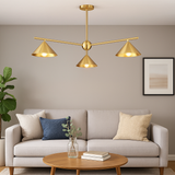 Modern brushed brass chandelier with cone shades styled in a neutral-toned living room, elegant ceiling light for contemporary home interiors