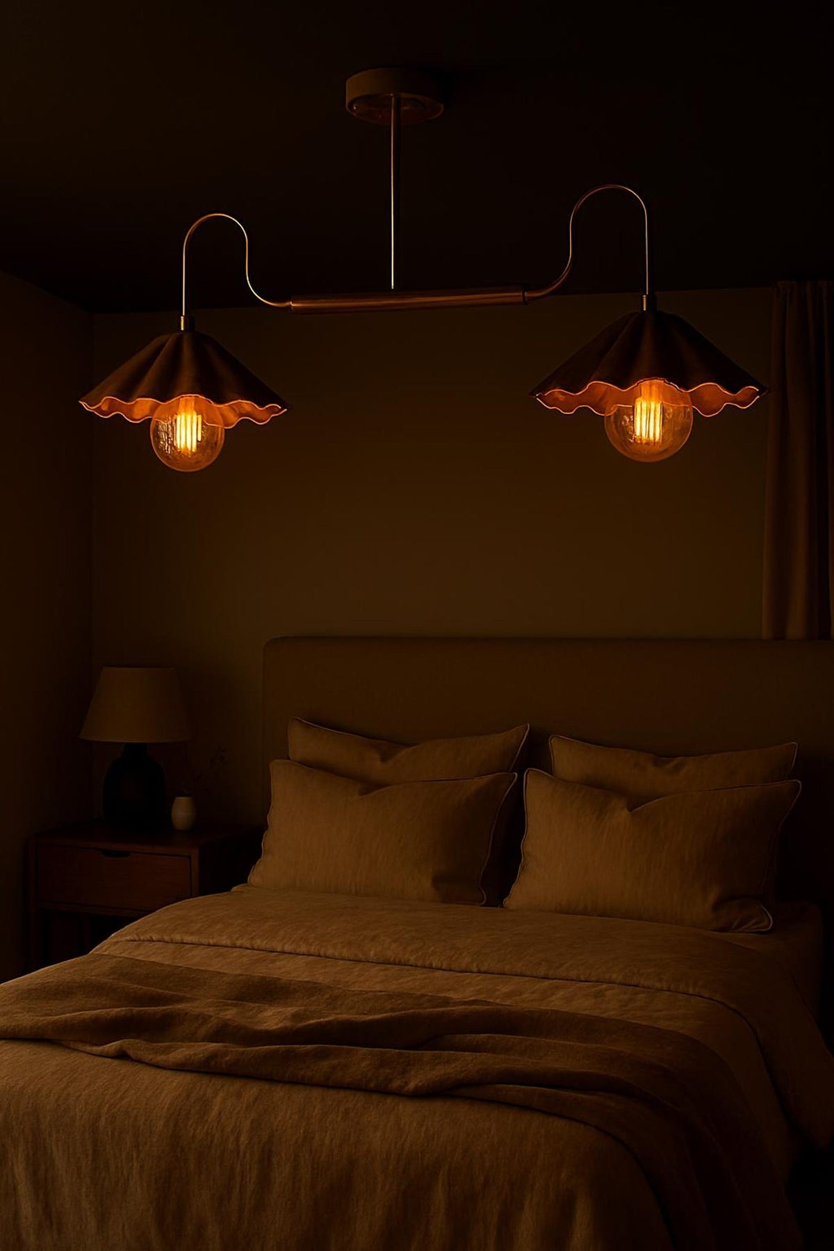Brushed brass 2-light chandelier with scalloped bowl shades creating soft ambient lighting in a dark bedroom interior