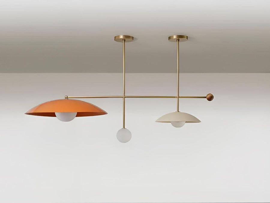 Modern linear ceiling chandelier crafted from solid brass featuring sculptural disc shades and soft ambient lighting in a minimalist contemporary interior.