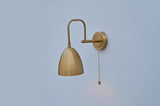 Modern dome wall light made of solid brass, featuring minimal round backplate and pull chain switch for easy control.