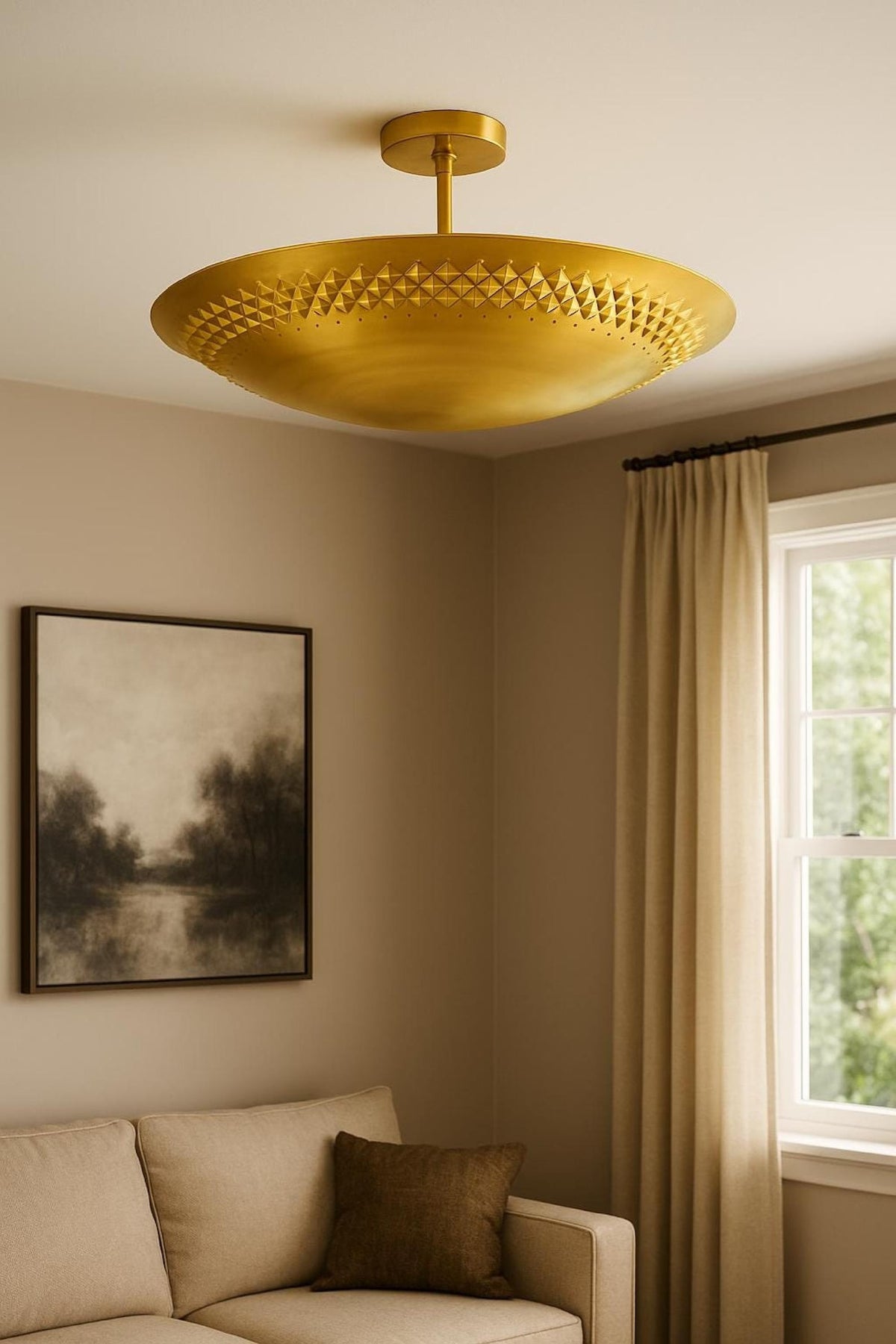Modern brass disc flush mount ceiling light installed in a warm neutral living room interior