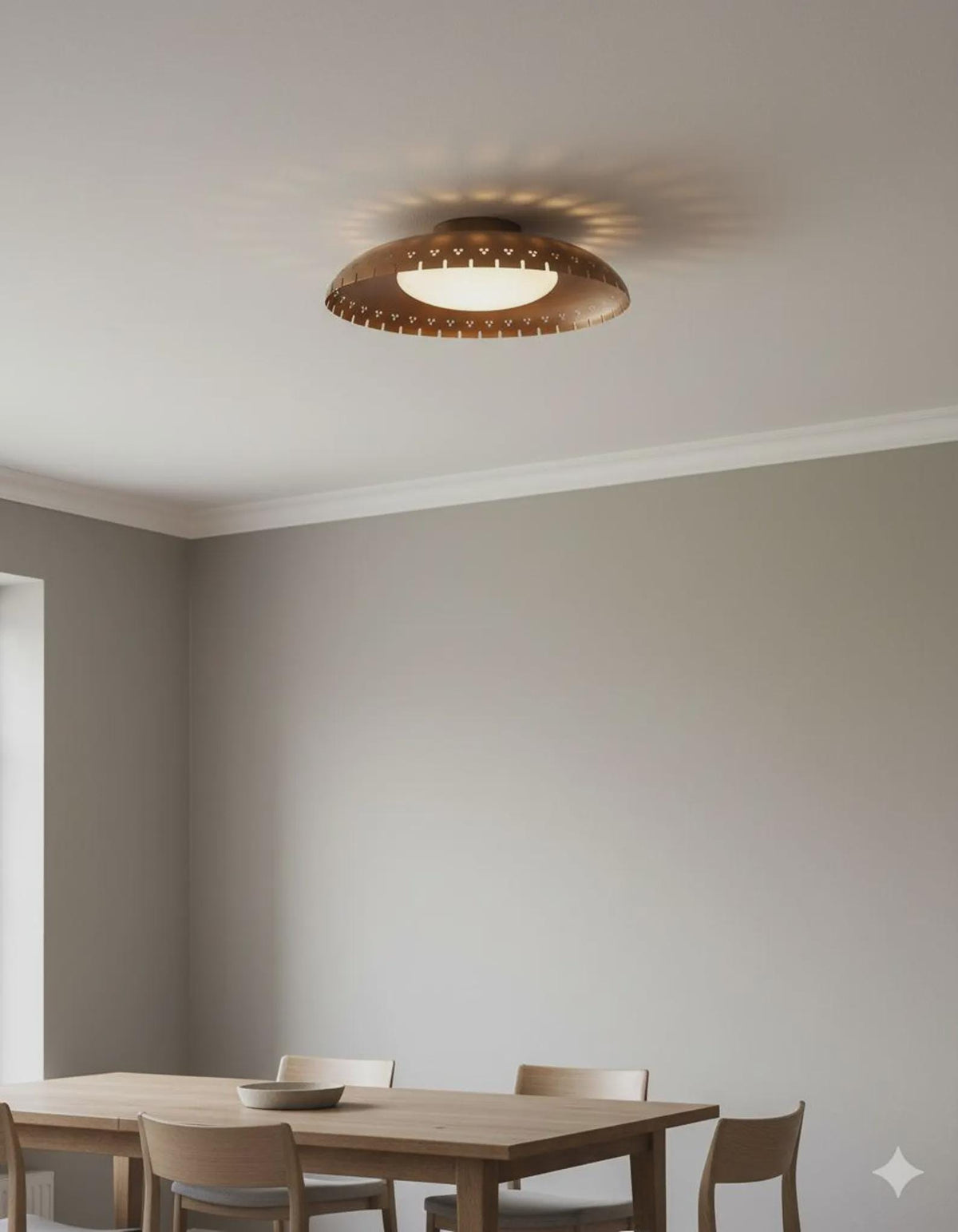 Minimal interior featuring a modern brass flush mount ceiling light with warm indirect glow and sculpted bowl form