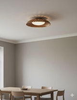 Minimal interior featuring a modern brass flush mount ceiling light with warm indirect glow and sculpted bowl form