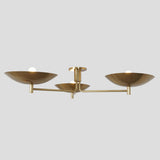 3-light brass flushmount ceiling light illuminated with soft warm bulbs for ambient modern lighting
