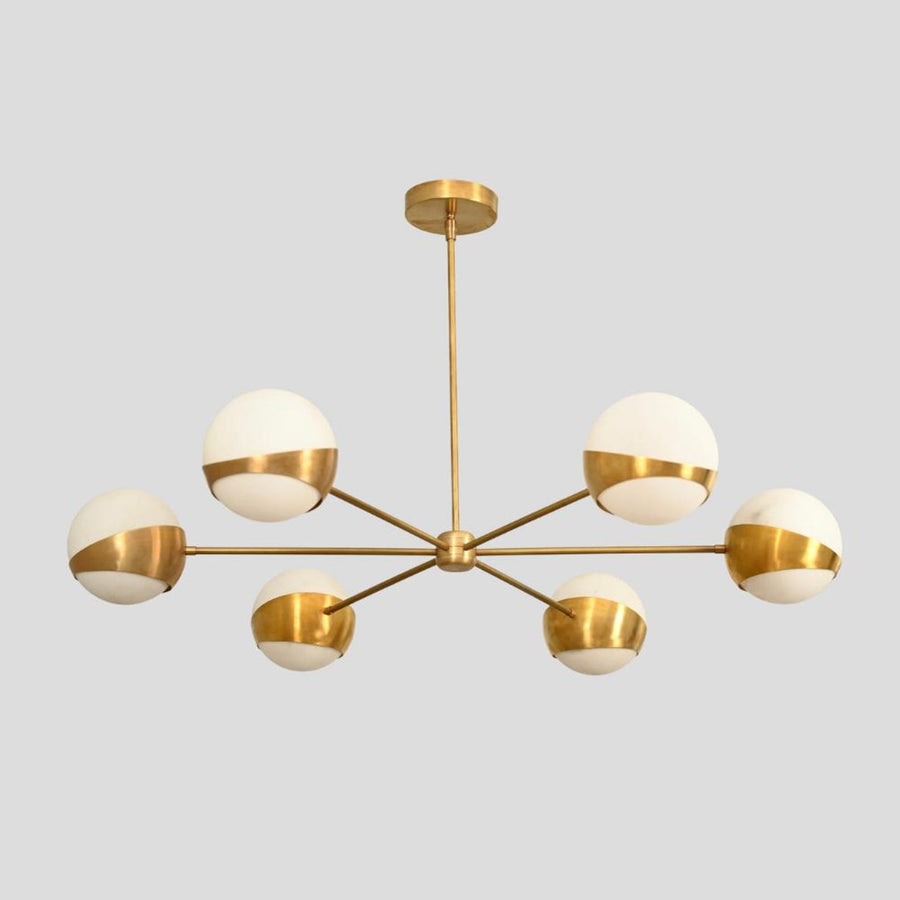 Modern brass globe chandelier with six opal glass shades, handmade ceiling light fixture in brushed brass finish.