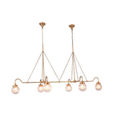 Side view of modern brass globe chandelier showing long horizontal body, curved arms, and textured glass shades