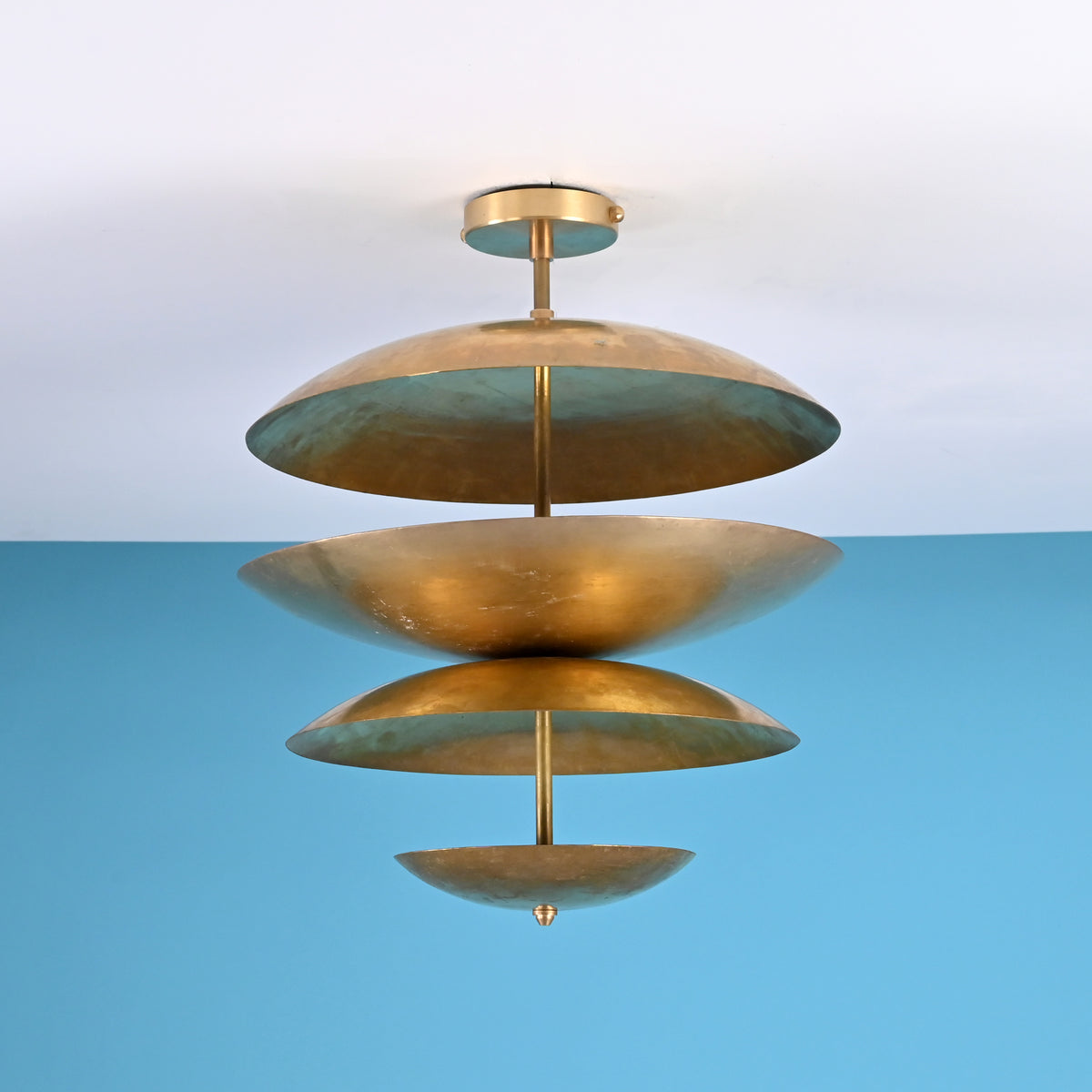 Sculptural layered brass ceiling light featuring bowl-shaped disc shades in a modern industrial flush mount design.