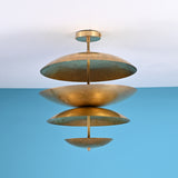 Sculptural layered brass ceiling light featuring bowl-shaped disc shades in a modern industrial flush mount design.
