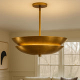 Modern solid brass layered disc pendant chandelier suspended from ceiling in warm brushed finish