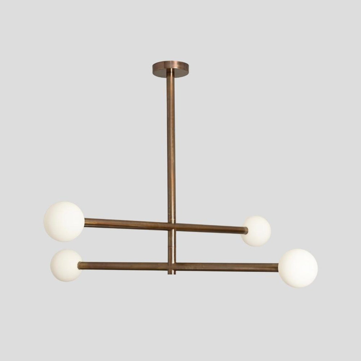 Modern brass 4-light linear chandelier with frosted glass globes, handmade by Brass Leaf Studio.