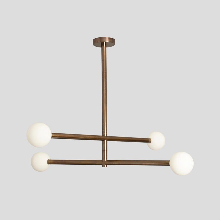 Modern brass 4-light linear chandelier with frosted glass globes, handmade by Brass Leaf Studio.