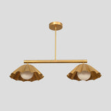 Modern brass pendant chandelier featuring two sculpted ruffle shades with globe bulbs, adding elegance to contemporary spaces.