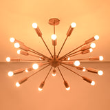 Modern brass sputnik chandelier shown from angled perspective with glowing bulbs in dark space.