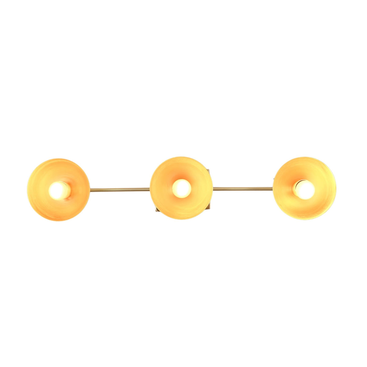 Modern brass wall light closeup showing rounded reflectors and warm bulb glow for boutique interior styling