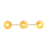 Modern brass wall light closeup showing rounded reflectors and warm bulb glow for boutique interior styling