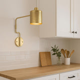 Modern brass wall light with adjustable arm installed above kitchen countertop backsplash