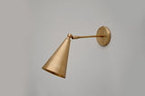 Modern brass wall sconce featuring adjustable arm and conical shade for directional lighting and elegant interior style.