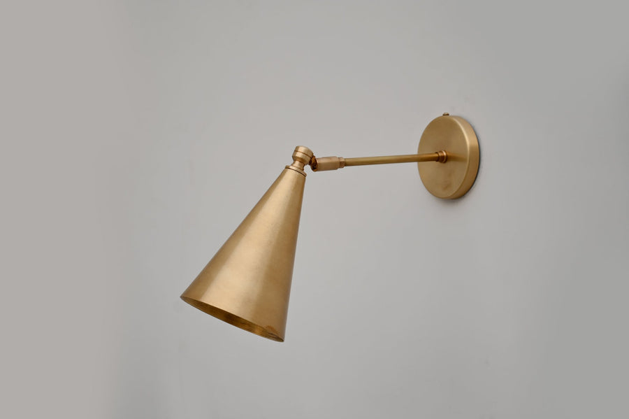 Adjustable brass cone wall light with brushed satin finish and minimalist design, handcrafted by Brass Leaf Studio.
