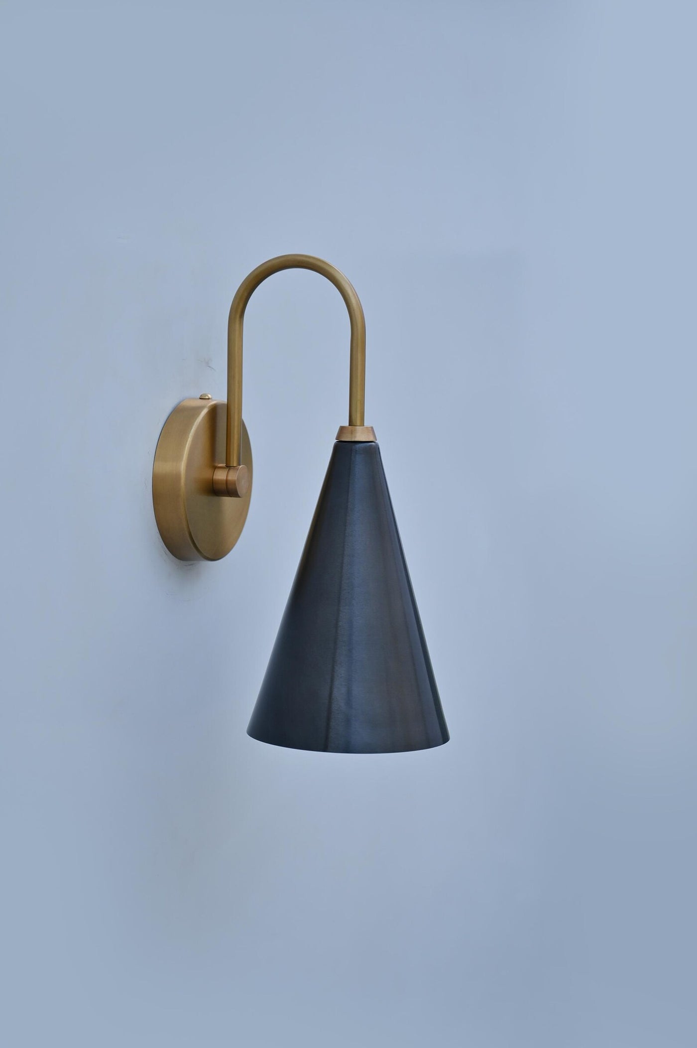 Modern brass wall sconce with black conical shade, handmade by Brass Leaf Studio for minimalist and industrial interiors