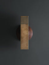 Modern brushed brass wall sconce with rectangular body and slotted top design mounted on dark wall