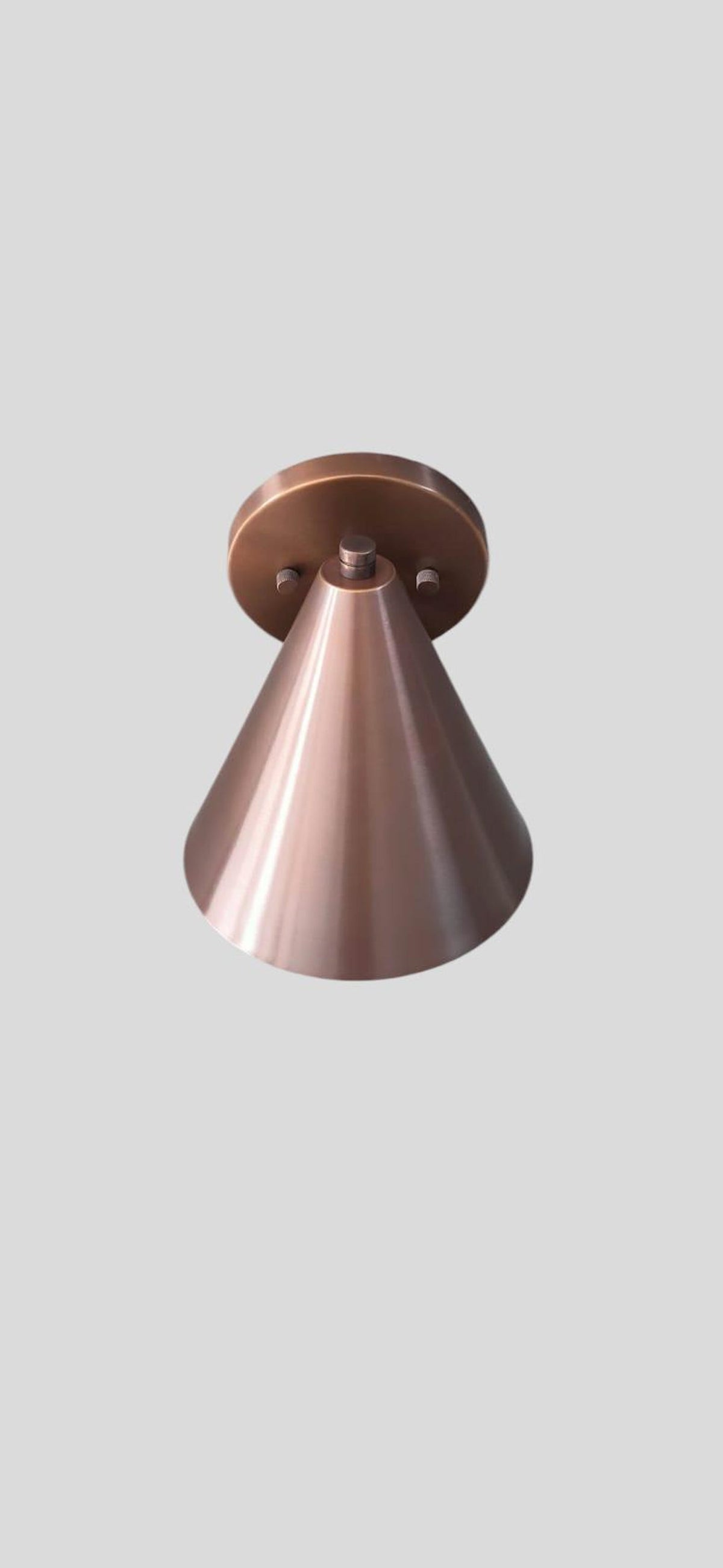 Front view of modern brushed copper wall sconce showcasing smooth cone shape and satin copper finish.