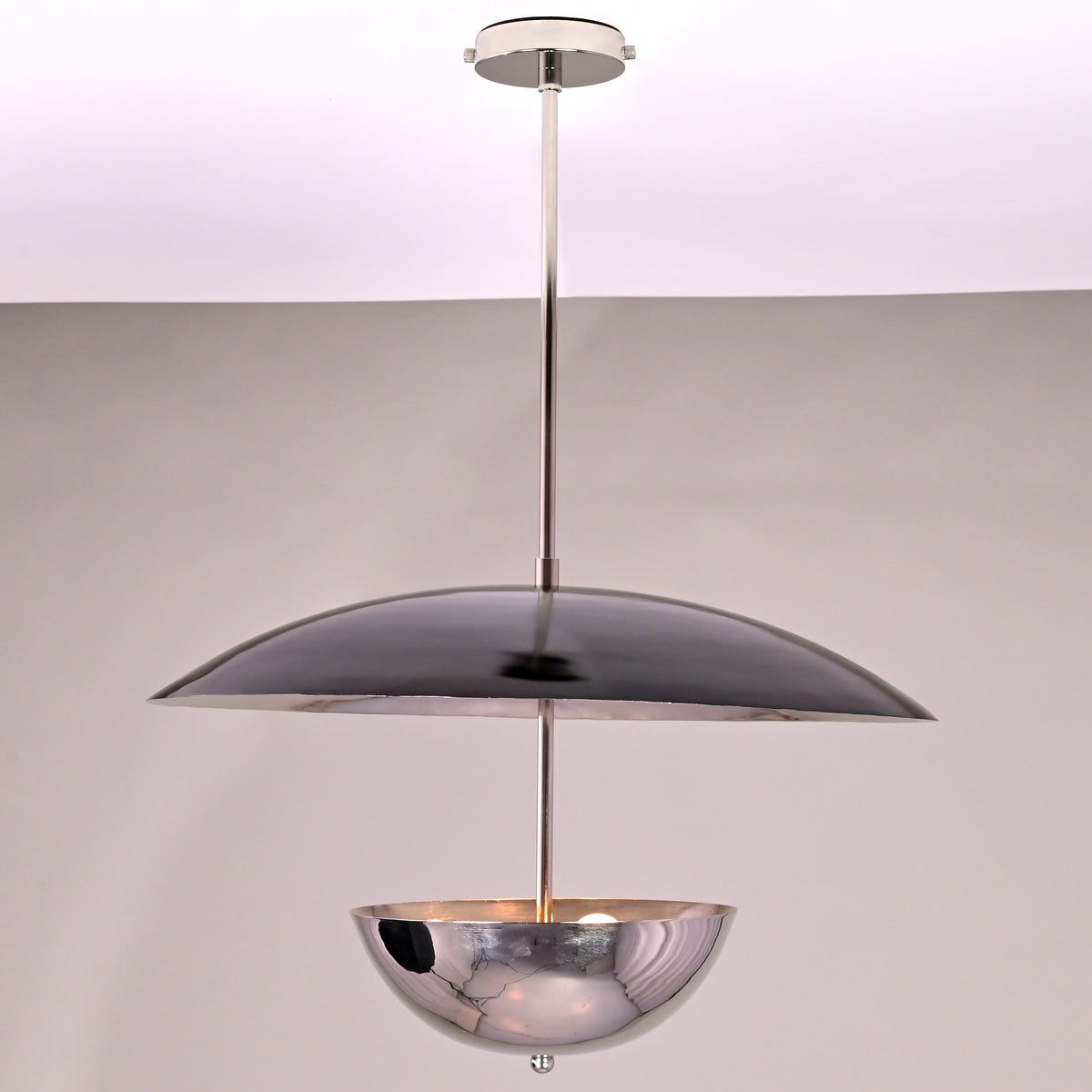 Side view of modern chrome brass chandelier with sculpted disc and bowl-shaped brass form