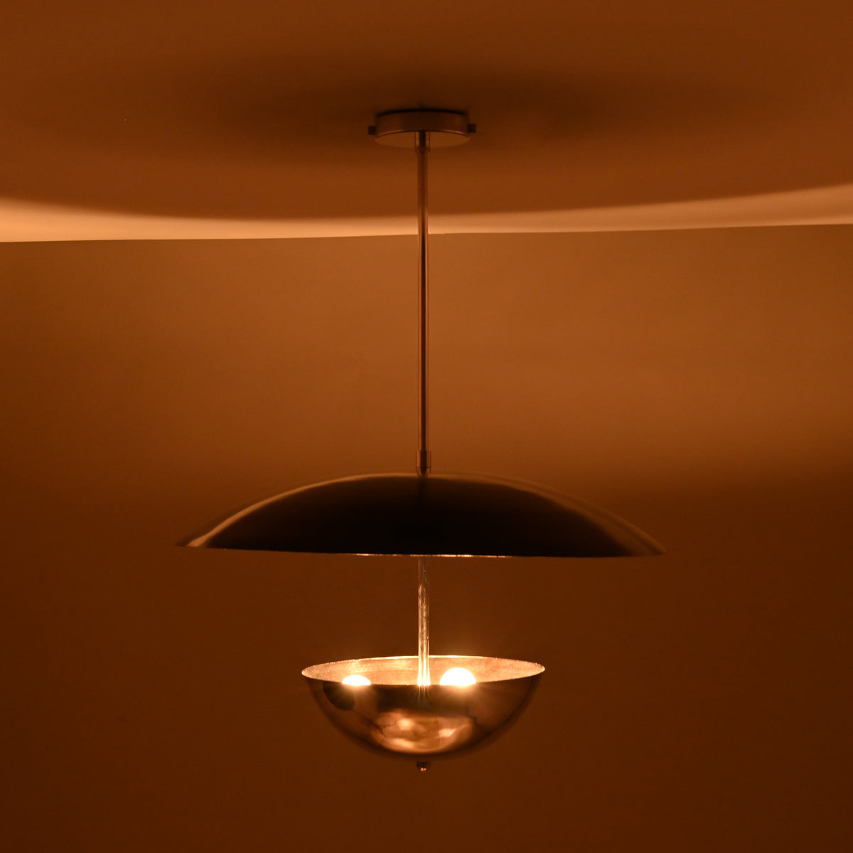Modern chrome brass chandelier showcasing warm lighting effect with reflective polished surfaces