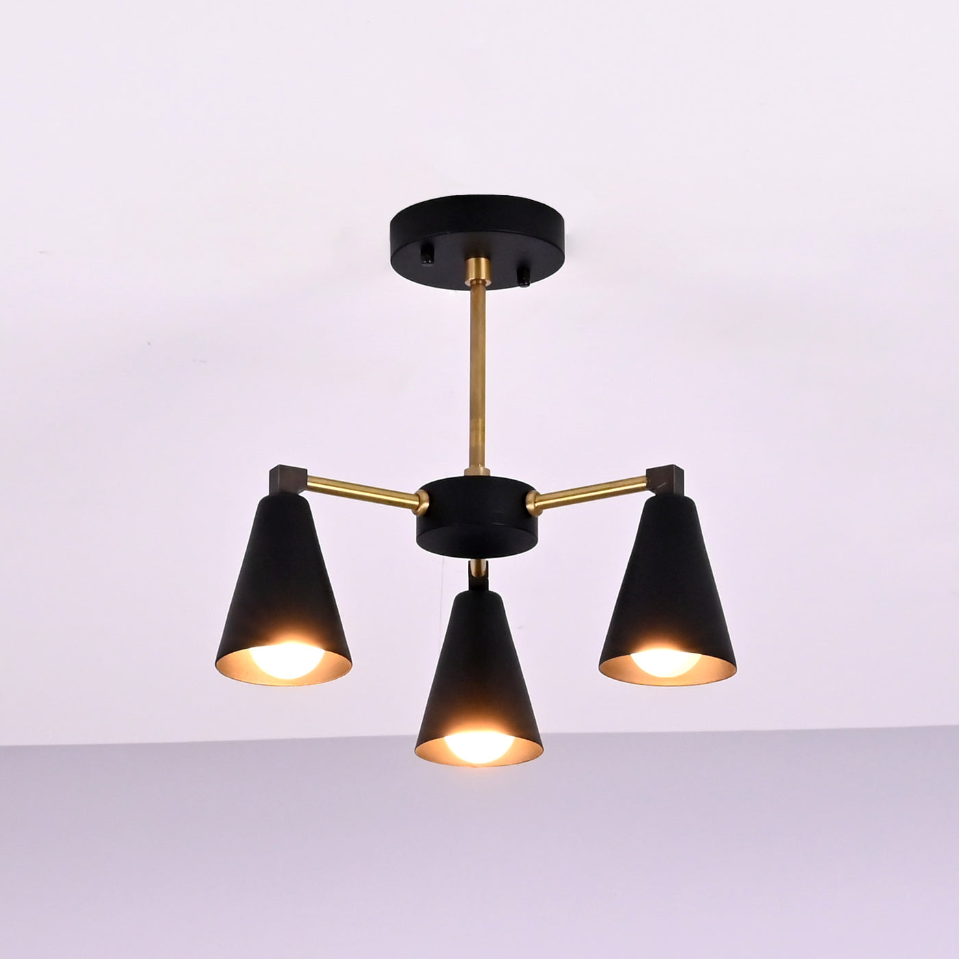 Angled view of modern cone brass ceiling light with balanced three arm configuration