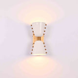 Modern diabolo wall sconce closeup showing white painted brass shades and brass hardware details