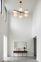 Modern oval glass ball chandelier installed above a dining area with soft warm lighting