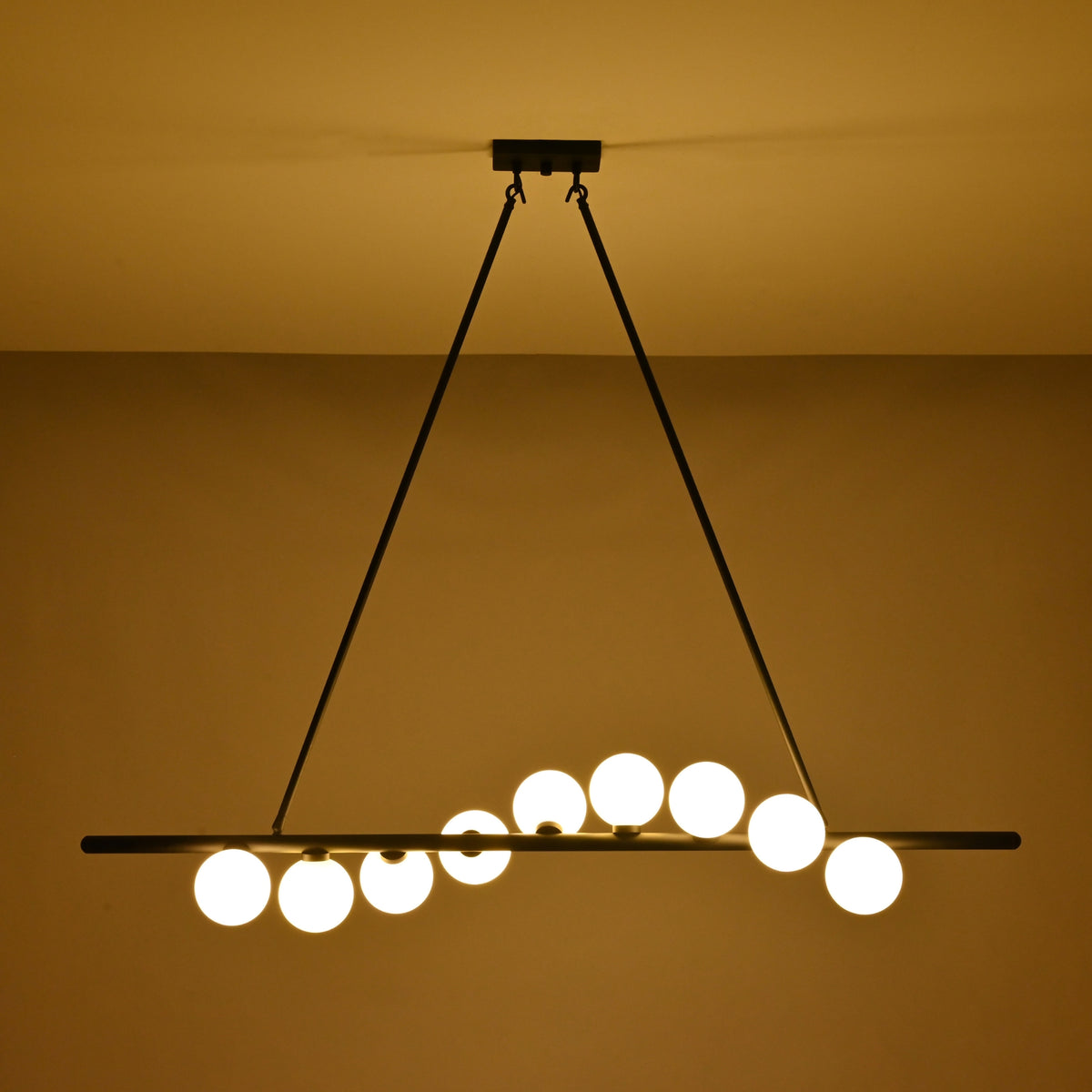Modern dining room globe chandelier suspended above a wooden table with soft warm lighting and elegant décor