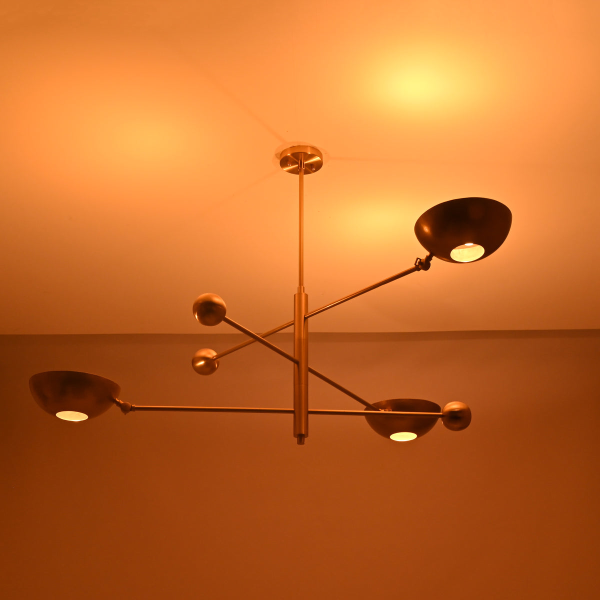 Night view of modern disc brass chandelier highlighting balanced symmetry and warm tones