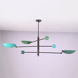 Modern brass disc chandelier with extended arms and colored shades viewed from an angled perspective