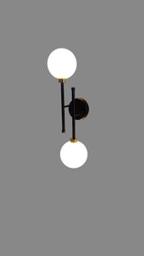 Modern black and brass double globe wall sconce with opal glass shades, vertical alignment design for elegant interior lighting.
