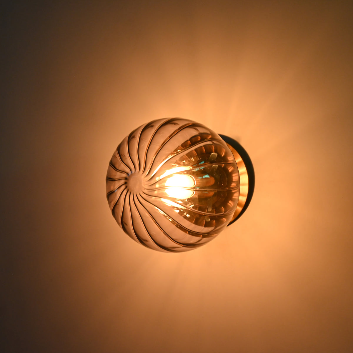 Modern glass globe wall fixture with ribbed shade and brass wall canopy for hallway, living room, or bedside use