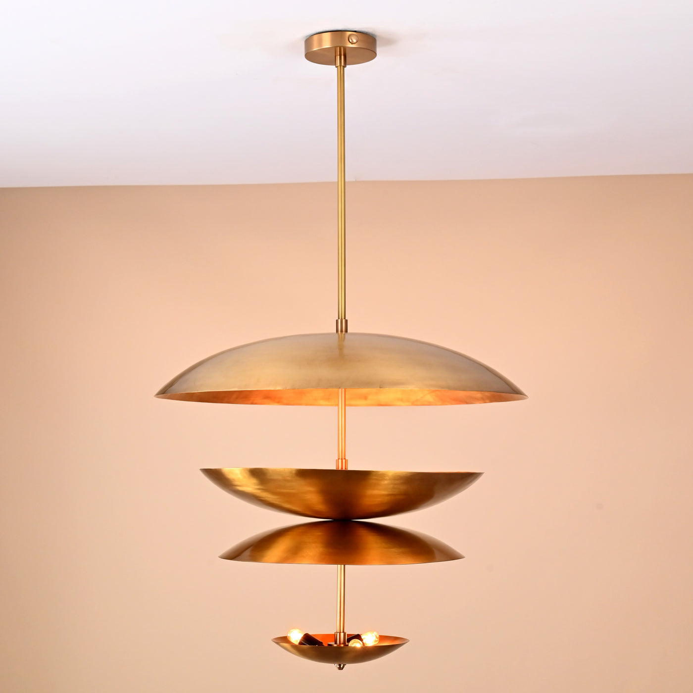 Front view of modern layered brass 6-light disc chandelier with sculptural floating bowl shades.