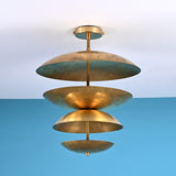 Sculptural layered brass ceiling light featuring stacked bowl-shaped discs in a modern industrial flush mount profile.