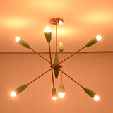 Modern mint green brass chandelier illuminated in dark room showing soft halo lighting effect.
