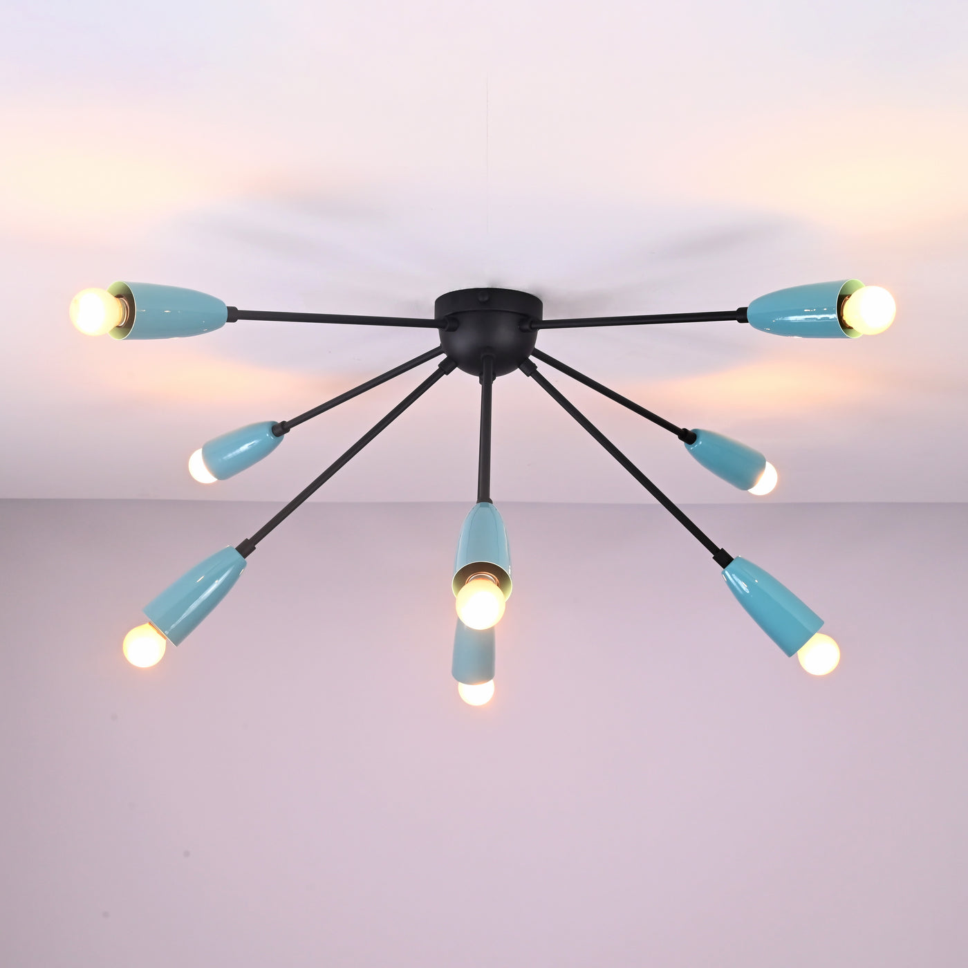 Modern orbit-style 8-light brass flush mount chandelier illuminated with warm ambient lighting