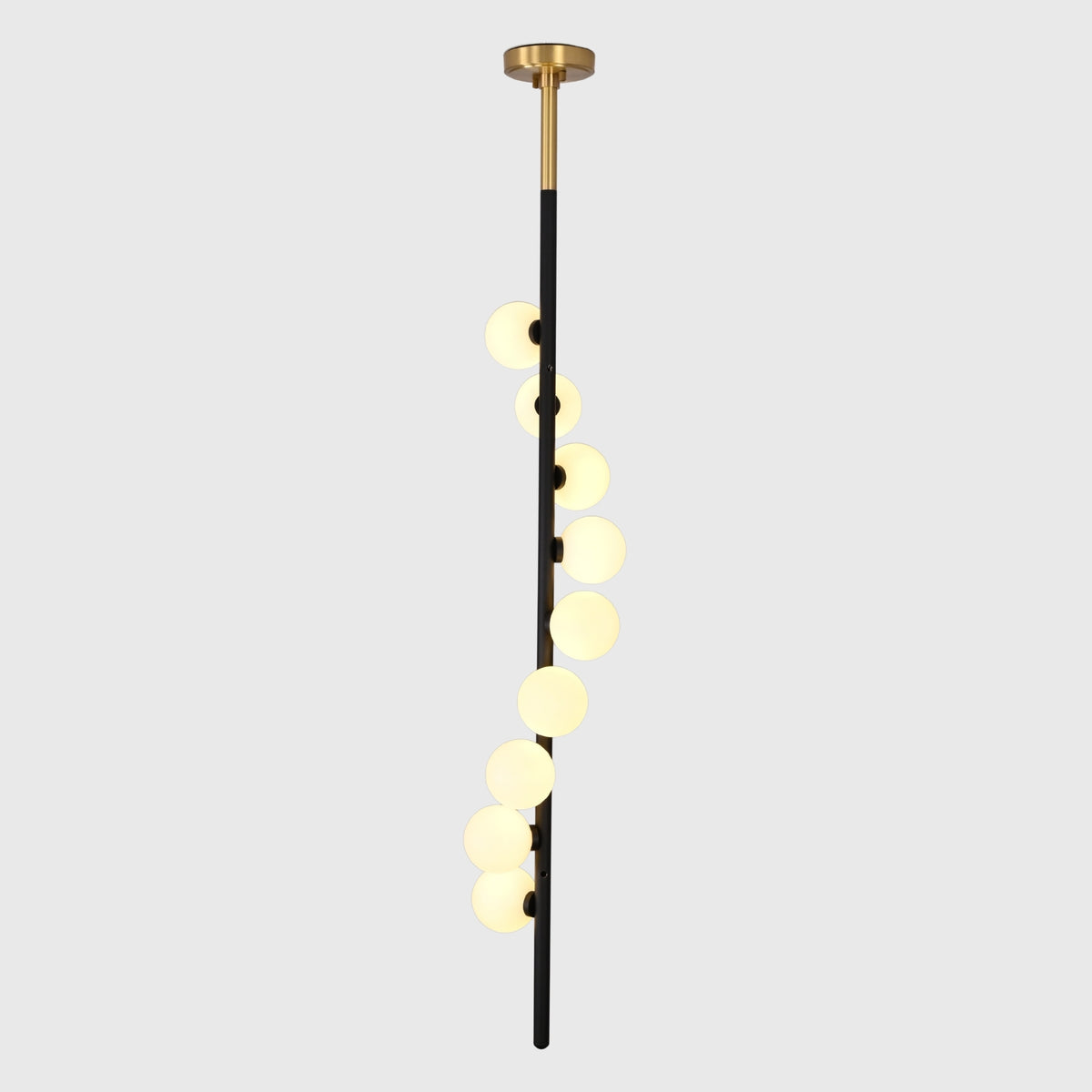 Modern stairwell globe chandelier shown from side angle with staggered round shades and tall vertical profile