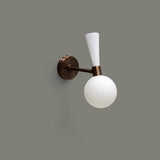 Side view of modern two-tone brass and white wall sconce with frosted glass globe shade