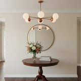 Monaco brass globe chandelier shown illuminated with warm ambient lighting and six glowing glass shades