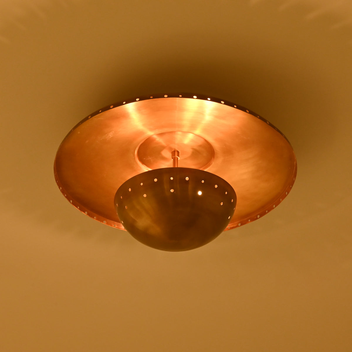 Mykonos brass patina flush mount installed in a refined bedroom with warm ambient lighting and neutral decor