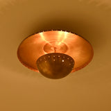 Mykonos brass patina flush mount installed in a refined bedroom with warm ambient lighting and neutral decor